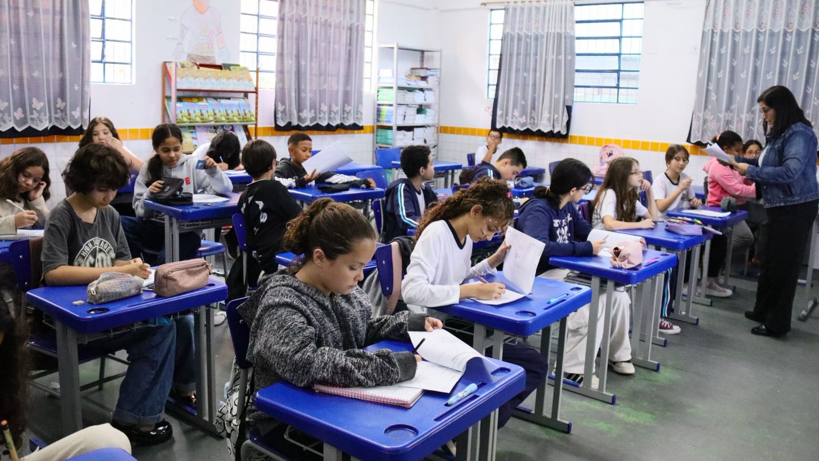 Estudantes realizam o Enem em sala de aula, com foco no transporte gratuito oferecido em Caraguatatuba.