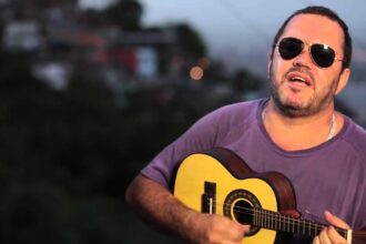 Fachada do Mercado Municipal de Santos Plínio Marcos durante evento cultural com público e música ao vivo.