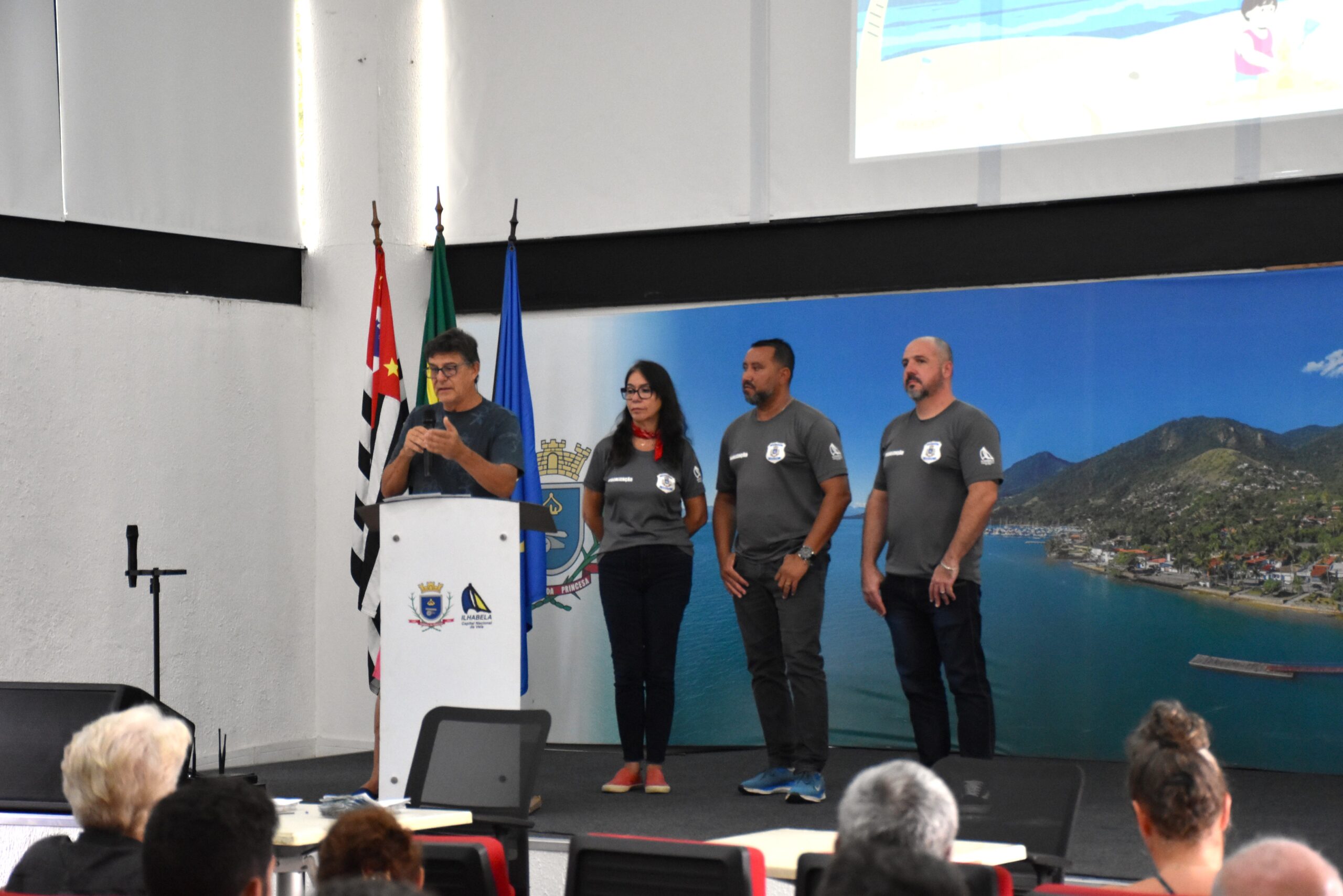 Prefeito Toninho Colucci entregando o Guia do Ambulante Legal para um comerciante no Paço Municipal de Ilhabela