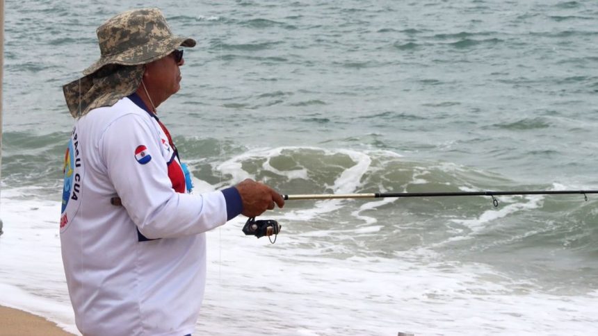 Atletas participam de competição de pesca esportiva na praia durante campeonato paulista.