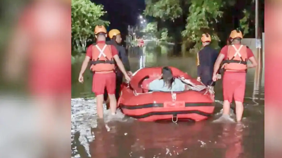 Rua alagada após chuva forte com atuação da Defesa Civil em cidade do litoral paulista.