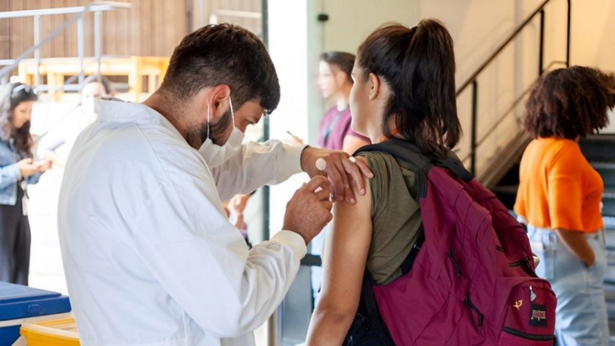Profissional de saúde aplicando vacina contra a gripe em unidade de saúde