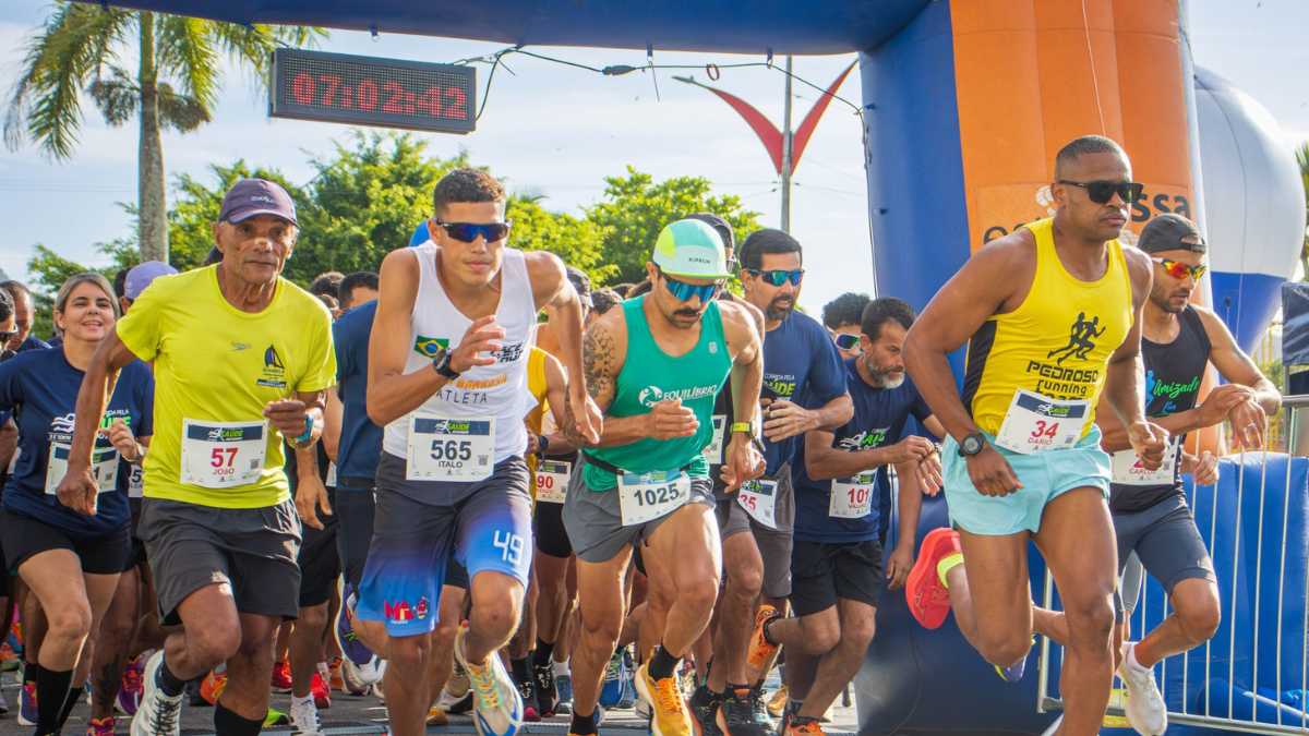 Corredores participando de prova de rua em Caraguatatuba com vista para o litoral