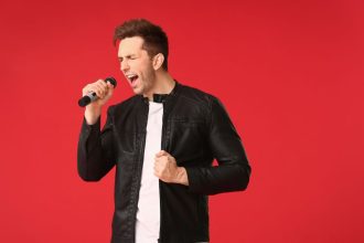 Pessoa cantando e mostrando uma sobrecarga vocal