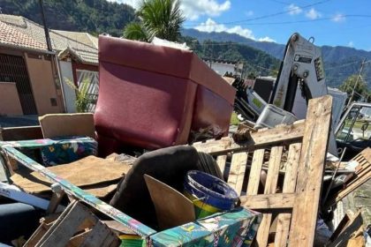Caminhão da Operação Cata-Treco recolhendo móveis e objetos descartados em rua residencial