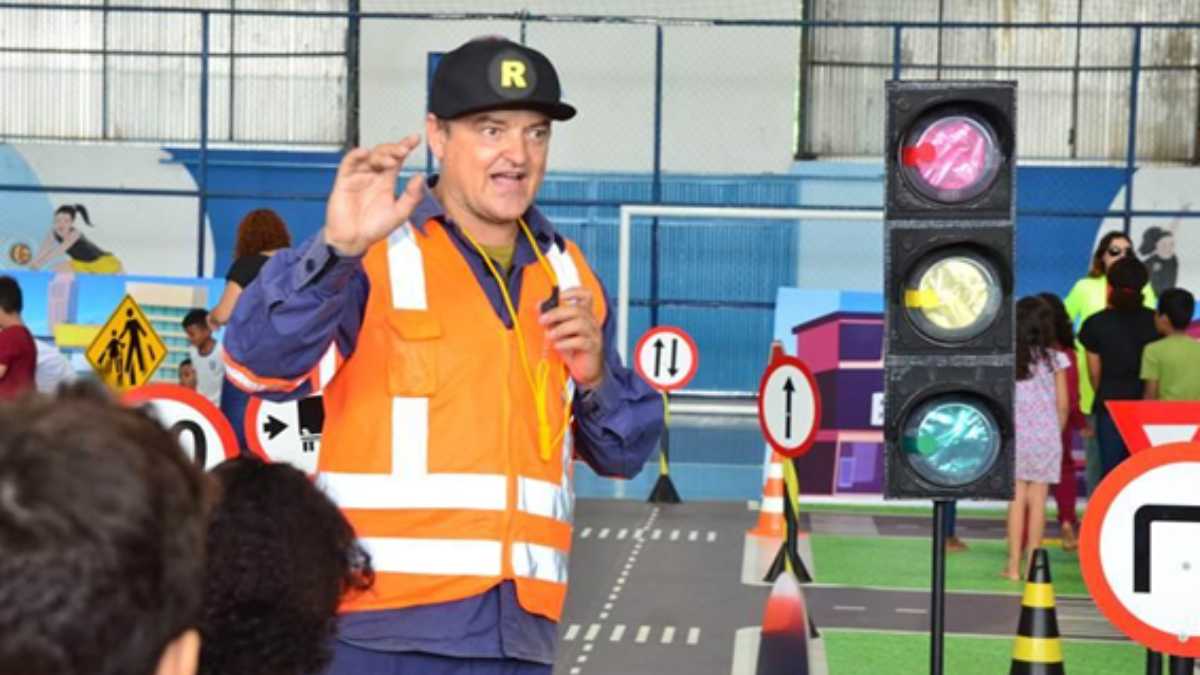 Crianças assistindo peça teatral educativa sobre trânsito em escola pública