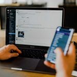Pessoa utilizando smartphone e computador simultaneamente, ilustrando os efeitos do excesso de estímulos digitais sobre a atenção e a saúde do cérebro
