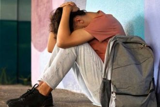 Adolescente sozinho durante as férias escolares, período que pode aumentar a sensação de isolamento e exigir atenção dos pais